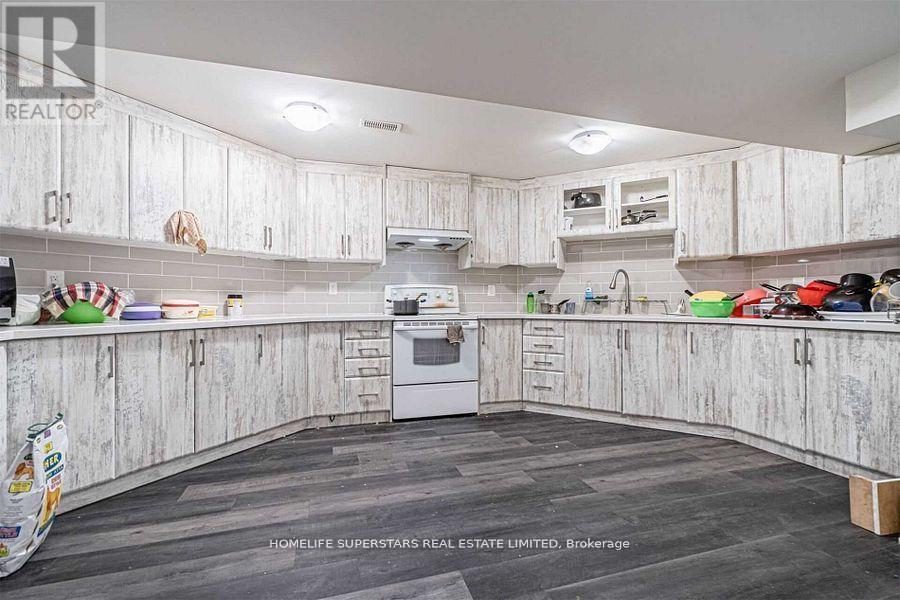 A kitchen with white cabinets and a wooden floor.