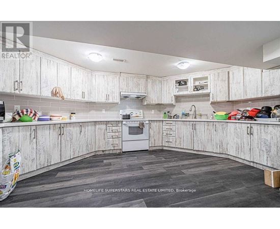 A kitchen with white cabinets and a wooden floor.
