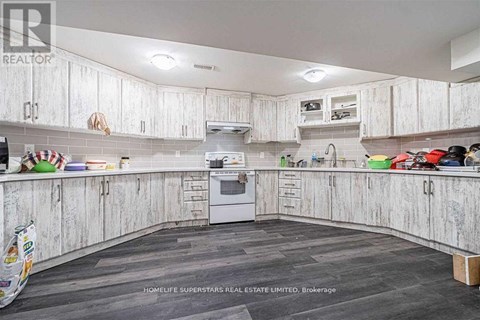 A kitchen with white cabinets and a wooden floor.