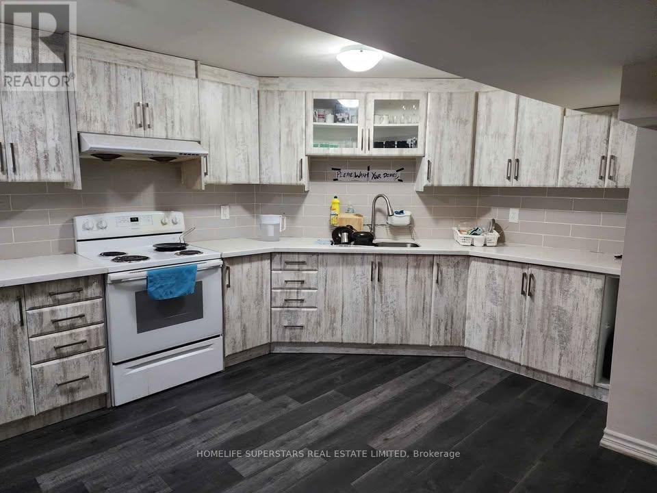 A kitchen with white cabinets and a white stove top oven.