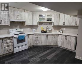 A kitchen with white cabinets and a white stove top oven.