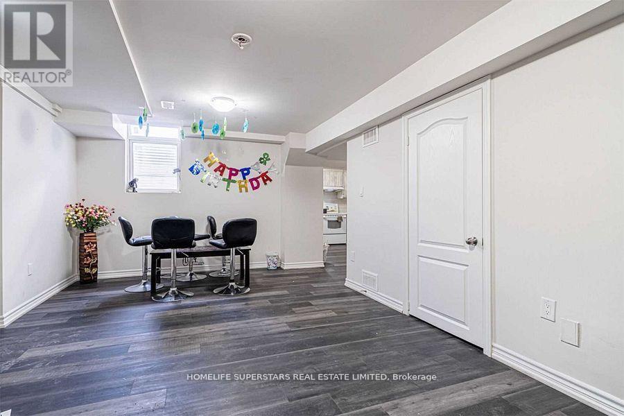 A room with a dining table and chairs with a sign that says "Happy Birthday" hanging on the wall.