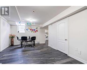 A room with a dining table and chairs with a sign that says "Happy Birthday" hanging on the wall.