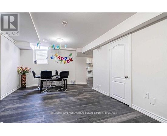 A room with a dining table and chairs with a sign that says "Happy Birthday" hanging on the wall.