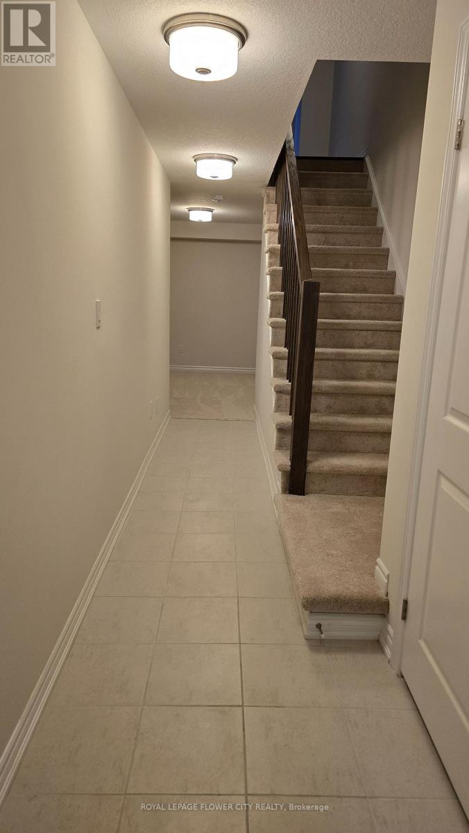 A hallway with a staircase and lights on the ceiling.