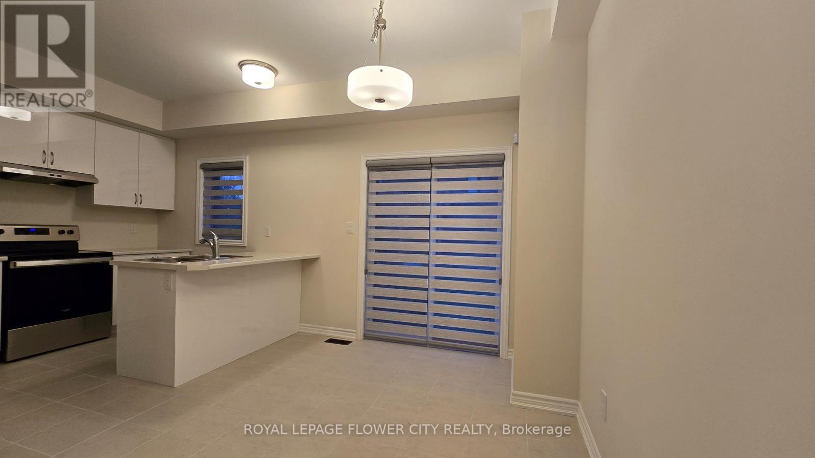 A kitchen area with a sink and a window with blinds.