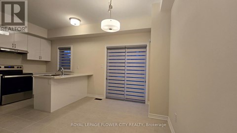 A kitchen area with a sink and a window with blinds.