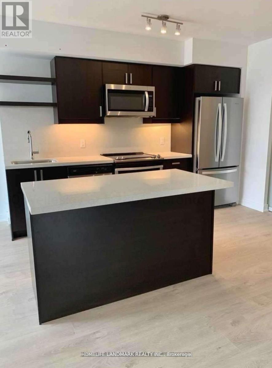 A kitchen with a black counter top and a white fridge.