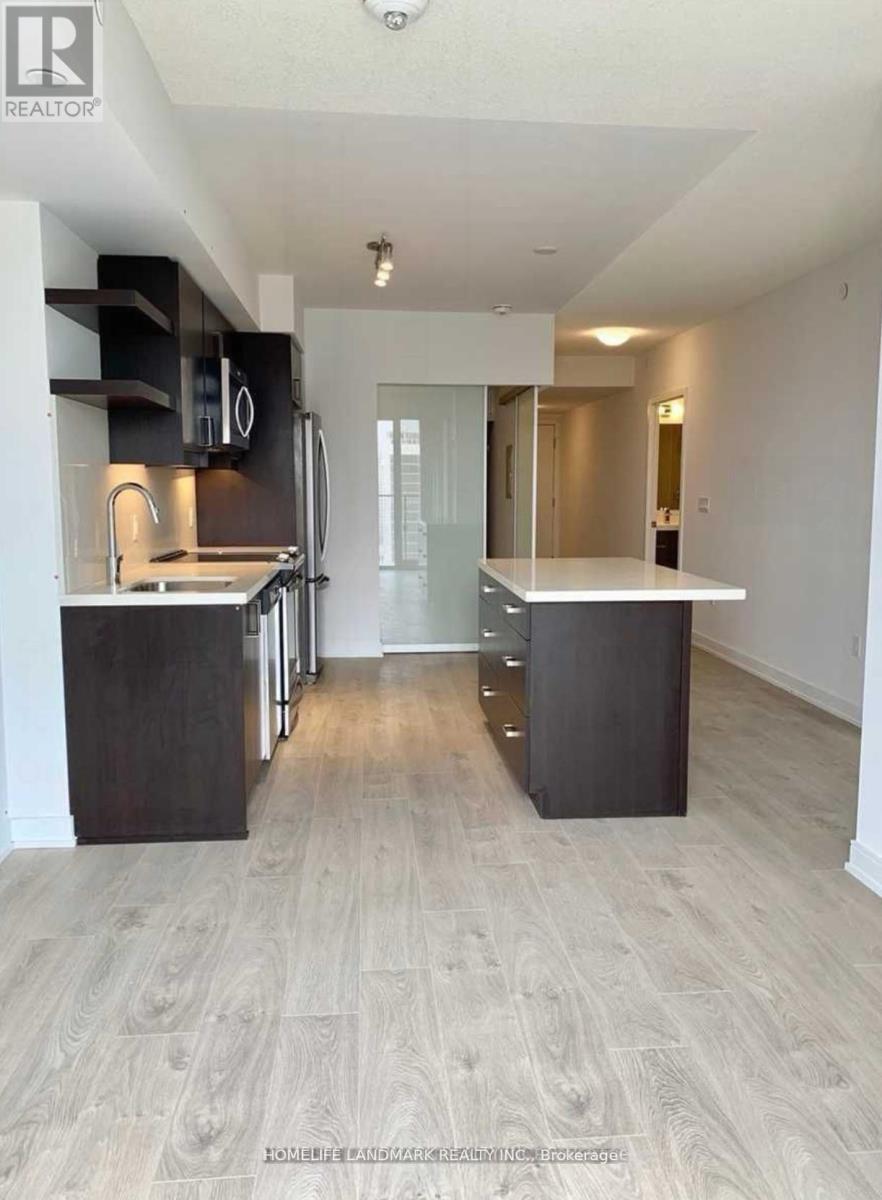 A spacious kitchen with a refrigerator, oven, and sink.