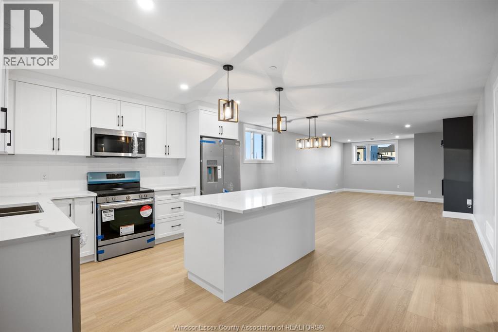 A kitchen with white cabinets and a large island.
