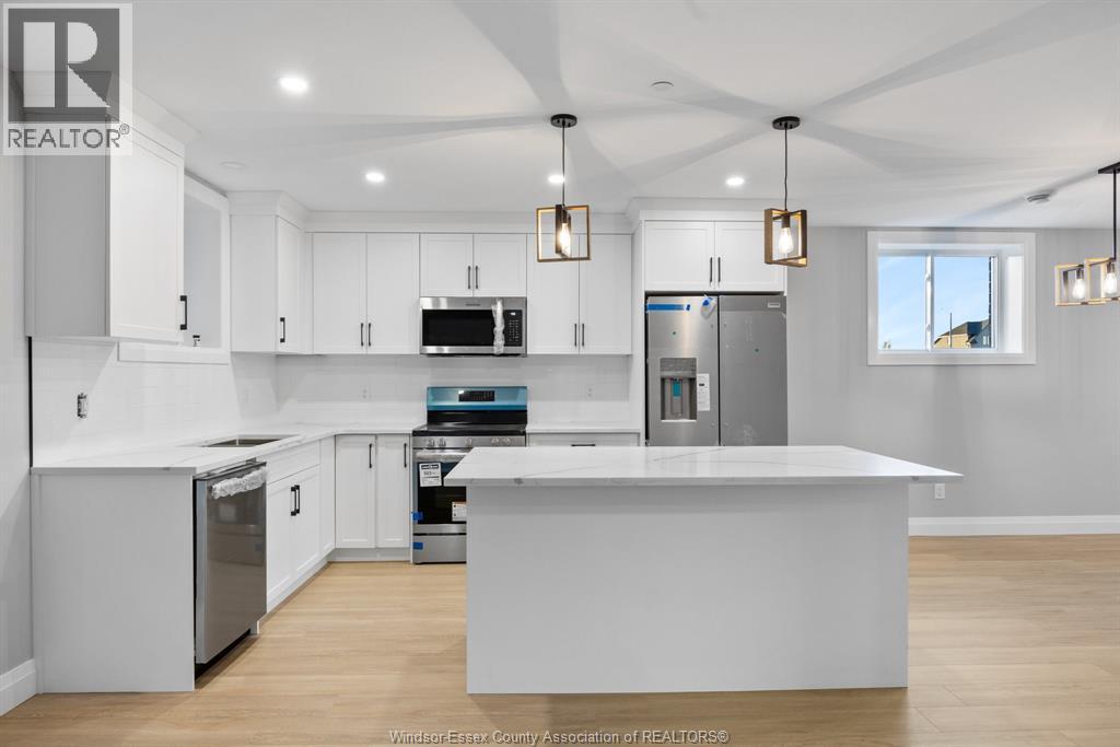 A kitchen with white cabinets and a large island.