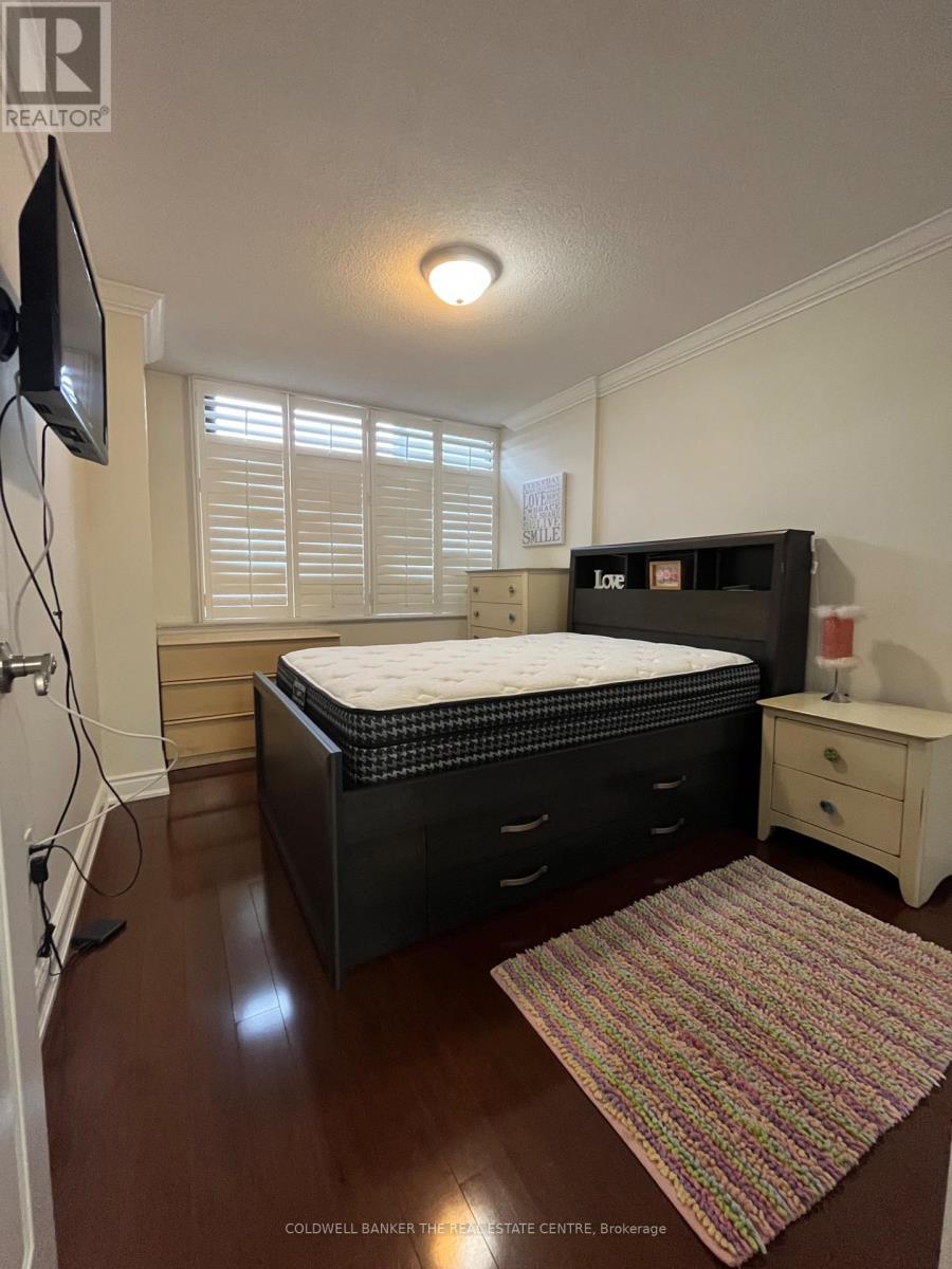 A bedroom with a bed, dresser, and window with blinds.