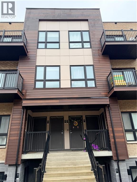 A brown building with a black railing and a black door.
