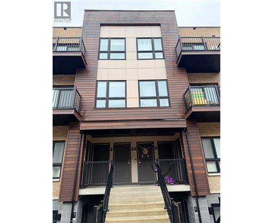 A brown building with a black railing and a black door.