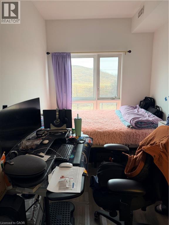 A messy room with a desk and a bed.