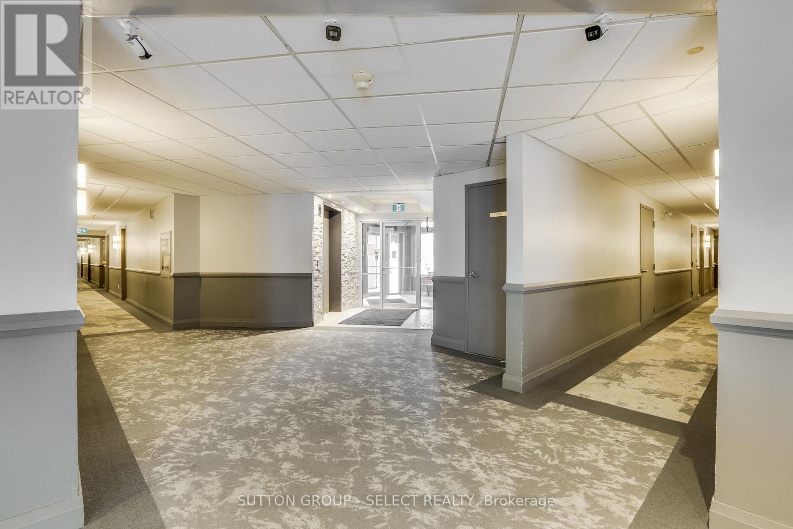A spacious office hallway with a marble floor and white walls.