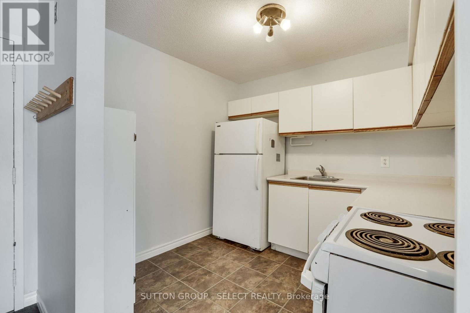 A small kitchen with a white refrigerator and a white stove top oven.