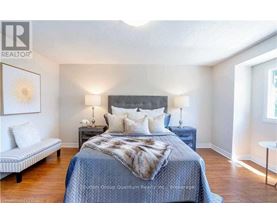 A bedroom with a bed, nightstands, and a bench.