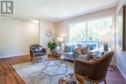 A living room with a brown chair and a glass table with a plant on it.