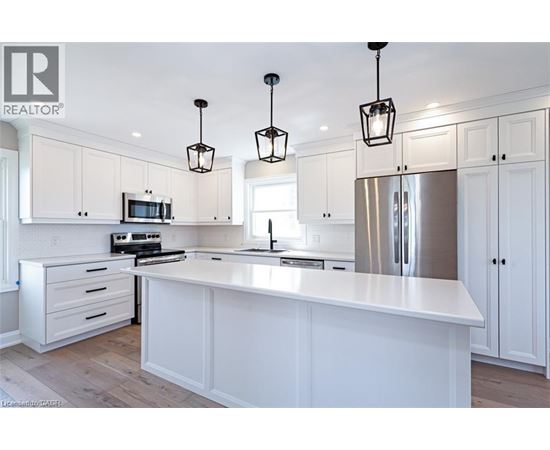 A modern kitchen with white cabinets and a central island.