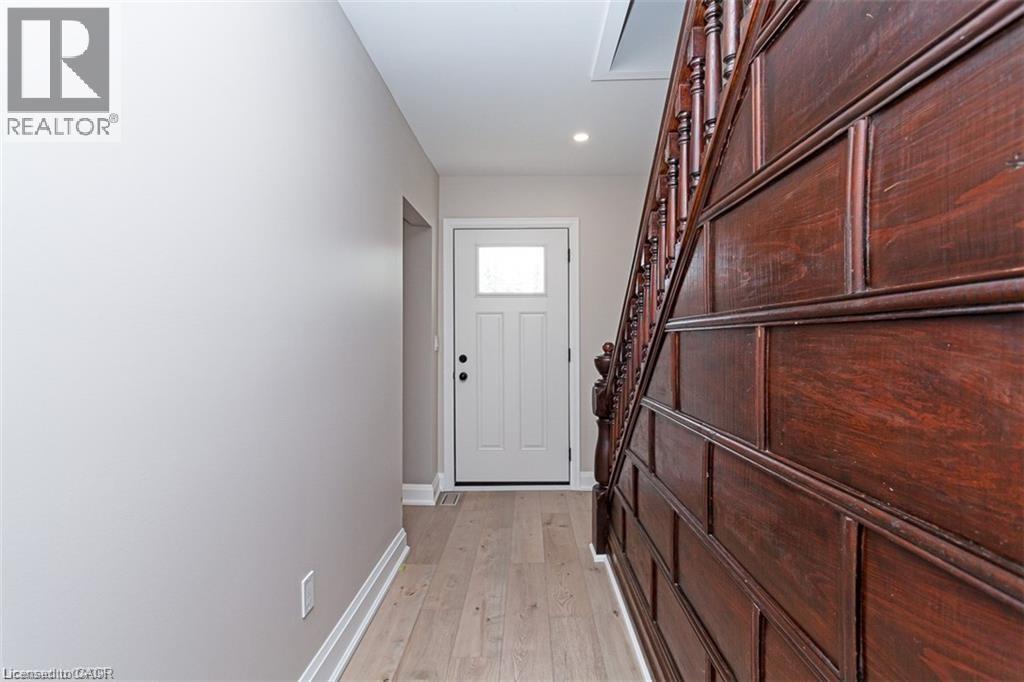 A hallway with a white door and wooden stairs.