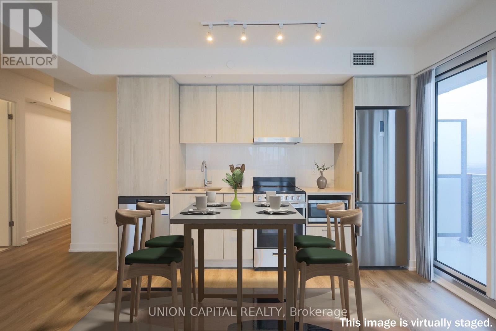 A dining room with a table set for two and a kitchen area in the background.
