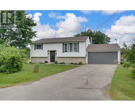 A white house with a grey garage door is for sale.