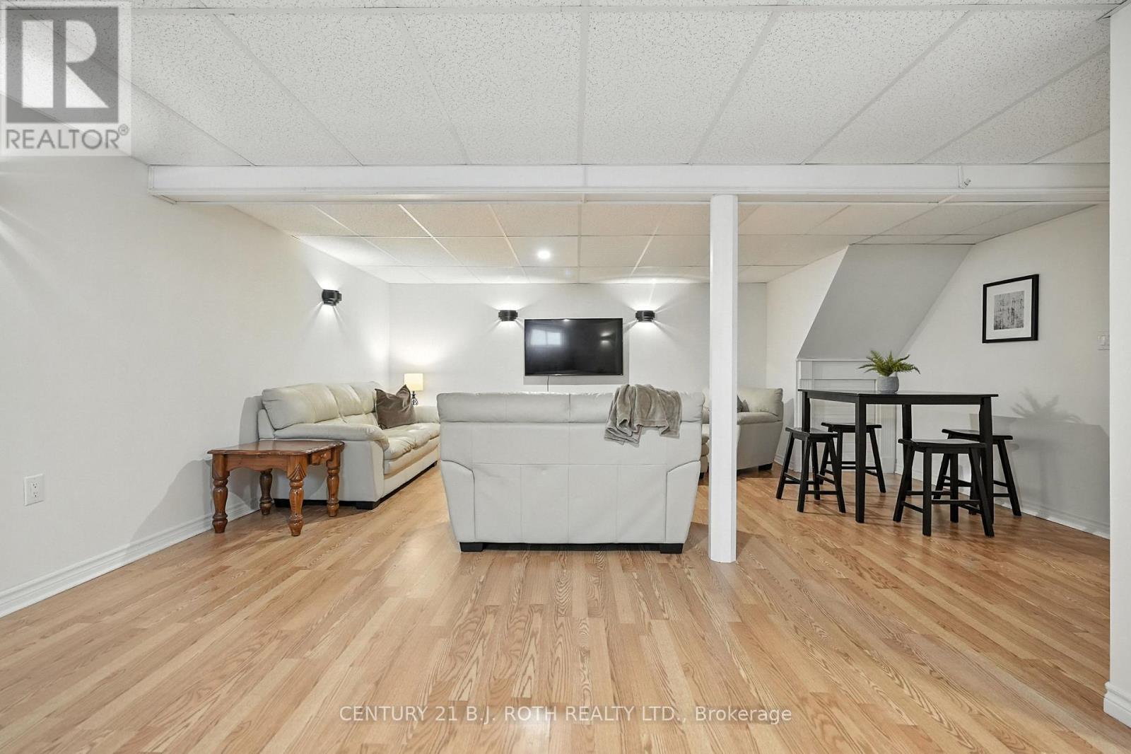 A living room with a white couch and a television.