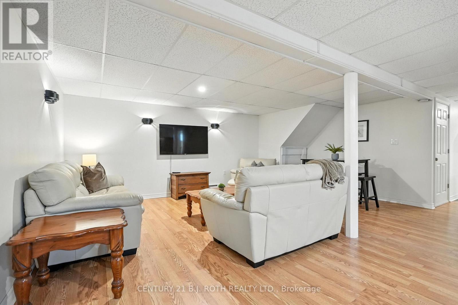A living room with a grey couch, a white couch, and a wooden table.