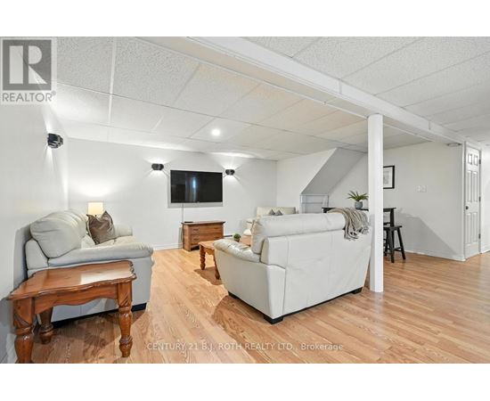 A living room with a grey couch, a white couch, and a wooden table.