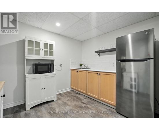 A kitchen with white cabinets and a stainless steel refrigerator.
