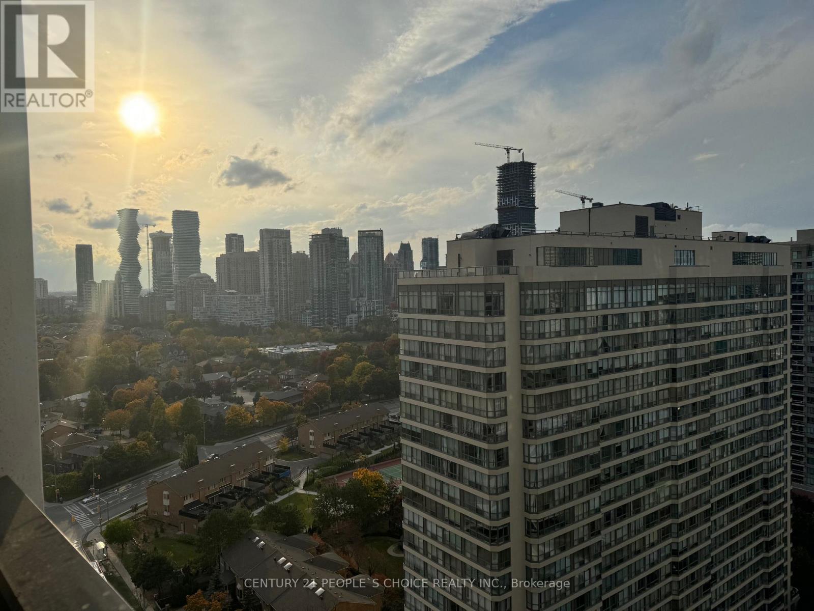 A sunny day in the city with a tall building in the foreground.