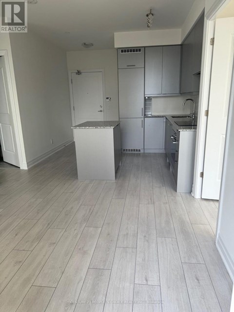 A kitchen with white cabinets and a white fridge.