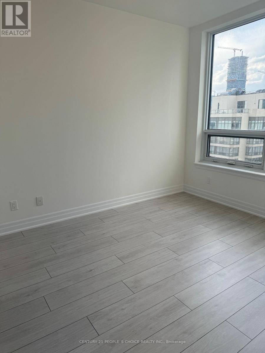 A room with a window and wooden flooring.