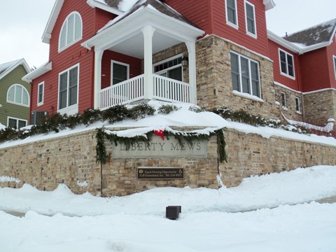 A red building with a sign that says "Liberty Mews" in front of it.