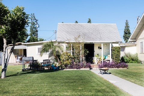 A house with a white front porch and a green lawn.