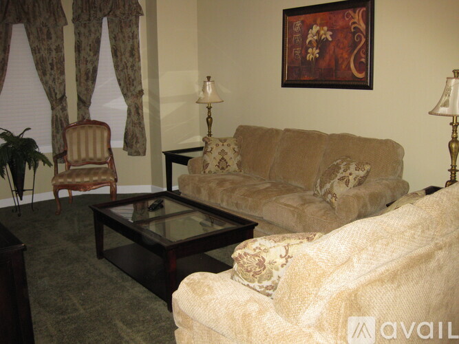 A living room with a couch, chair, and lamp.
