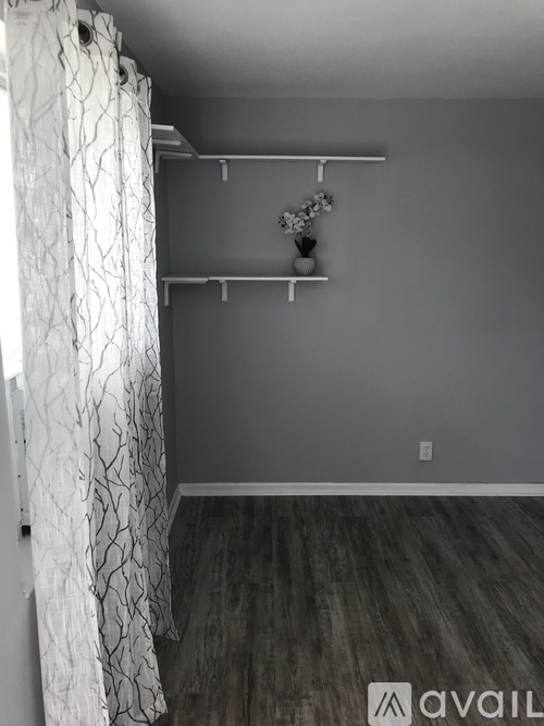 A room with a grey wall and a white curtain.