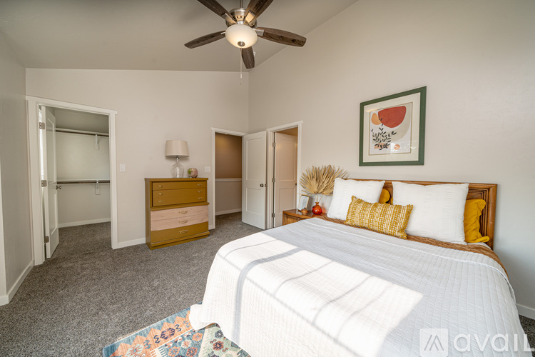 A bedroom with a large bed and a ceiling fan.