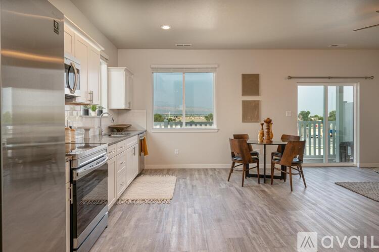 A modern kitchen with a dining table set for two.