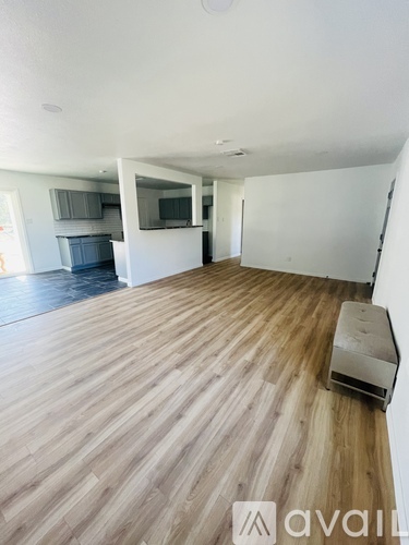 A room with wooden flooring and a wall-mounted air conditioner unit.