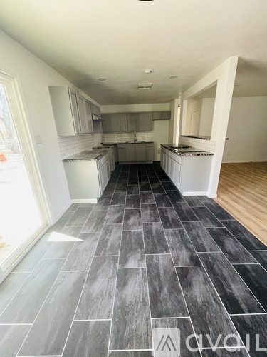 A kitchen with a grey floor and white walls.