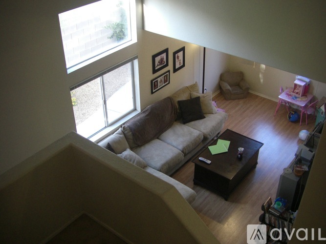 A living room with a couch, a coffee table, and a large window.