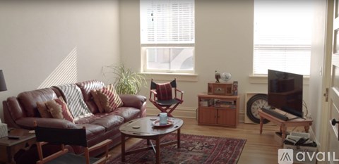 A living room with a red couch and a rug.