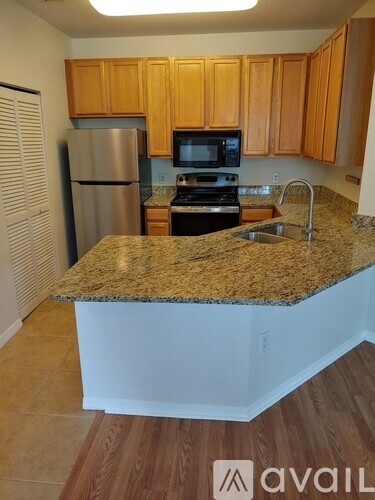 A kitchen with wooden cabinets and a granite countertop.