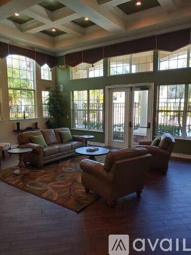 A living room with brown leather furniture and a large window.
