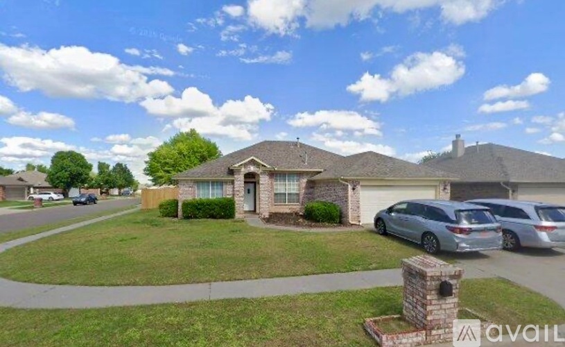 A house with a car parked in front and a stone pillar in the front yard.