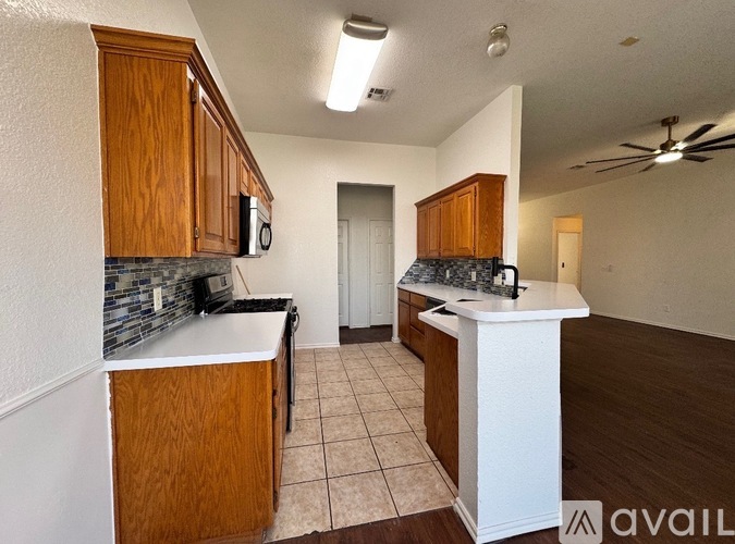 A kitchen with wooden cabinets and a white island.