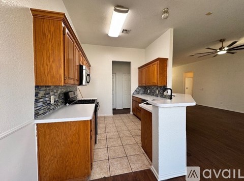 A kitchen with wooden cabinets and a white island.