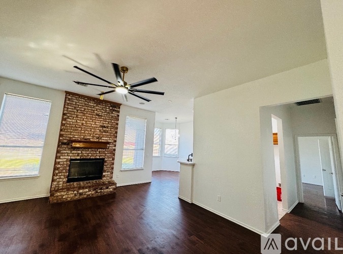 A living room with a fireplace and a ceiling fan.